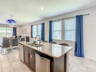 a kitchen and dining room with blue curtains at 160 Minton Loop in Orlando