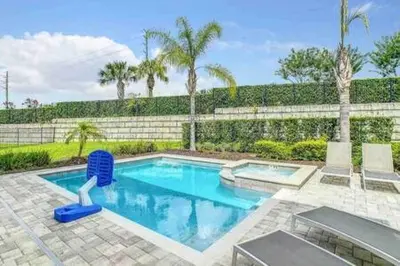 a swimming pool with a blue chair in a yard at 160 Minton Loop in Orlando