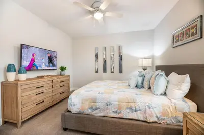 a bedroom with a bed and a dresser with a tv at 7484 Marker Avenue in Orlando