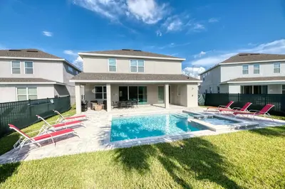 a house with a pool and chairs in the yard at 7484 Marker Avenue in Orlando