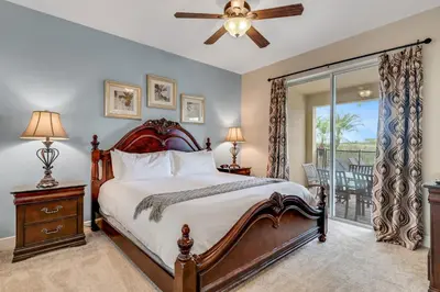 a bedroom with a large bed and a balcony at 7668 Wilmington Loop in Orlando