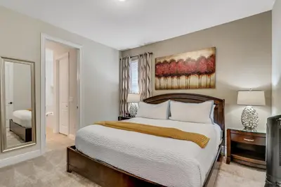 a bedroom with a large bed and a mirror at 7668 Wilmington Loop in Orlando