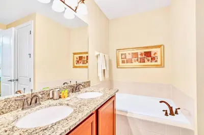 a bathroom with two sinks and a bath tub at 7668 Wilmington Loop in Orlando