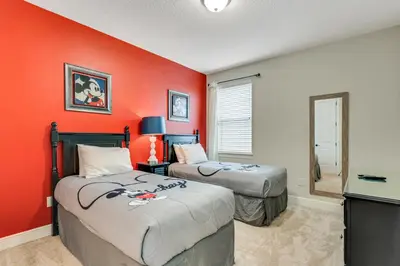 two beds in a room with an orange wall at 7668 Wilmington Loop in Orlando