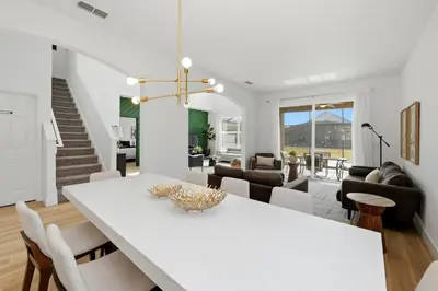 a dining room and living room with a white table and chairs at Freshly Updated Near Disney Private Pool Resort in Kissimmee
