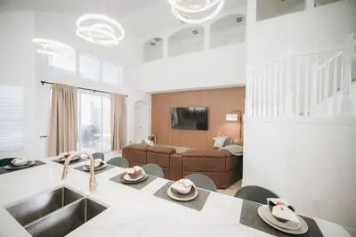 a kitchen and living room with a table and a couch at 6BR Family Vacation Home near Disney in Kissimmee