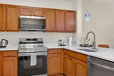a kitchen with wooden cabinets and stainless steel appliances at 3176-205 Resort Pool Condo Apt near Disney in Kissimmee