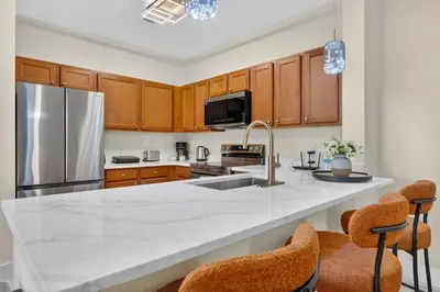 a kitchen with a white counter top and wooden cabinets at 3176-205 Resort Pool Condo Apt near Disney in Kissimmee