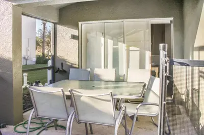 a glass table and chairs on a patio at Family Private Home W Heated Pool 12Min To Walt Disney in Kissimmee