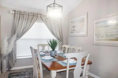 a dining room with a wooden table and chairs at Family Private Home W Heated Pool 12Min To Walt Disney in Kissimmee
