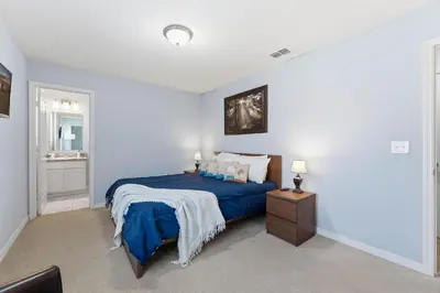 a bedroom with a bed with a blue comforter at Savvy 4Bed Stay Near Orlando Attractions in Kissimmee