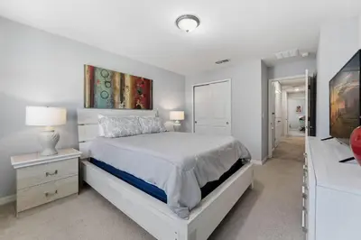 a white bedroom with a bed and a mirror at Savvy 4Bed Stay Near Orlando Attractions in Kissimmee