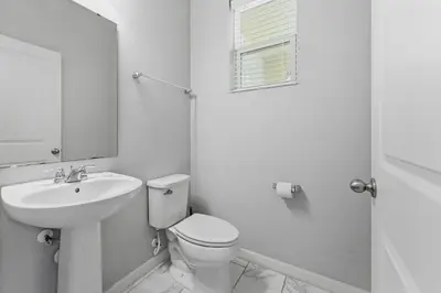 a white bathroom with a toilet and a sink at Savvy 4Bed Stay Near Orlando Attractions in Kissimmee