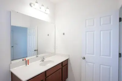 a bathroom with a sink and a mirror at Spacious Home - Veranda Palms w Heated Pool & BBQ in Kissimmee
