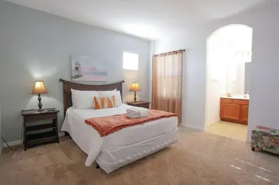 a bedroom with a large bed and a bathroom at Spacious Home - Veranda Palms w Heated Pool & BBQ in Kissimmee