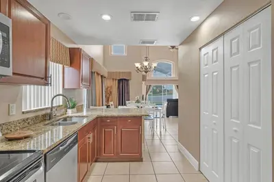 a kitchen with wooden cabinets and a white door at Lakefront Home Game Room & Views in Kissimmee