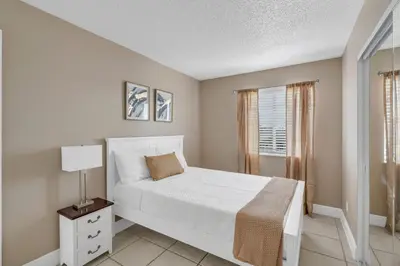 a bedroom with a white bed and a window at Lakefront Home Game Room & Views in Kissimmee