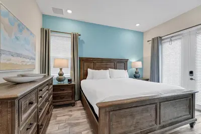 a bedroom with a large bed and two windows at Blush Breeze Cottage Near Disney With Private Pool & Margaritaville Resort And Island H20 Waterpark Access - 2940Sr in Orlando