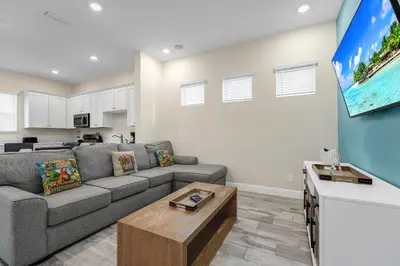 a living room with a couch and a tv at Blush Breeze Cottage Near Disney With Private Pool & Margaritaville Resort And Island H20 Waterpark Access - 2940Sr in Orlando