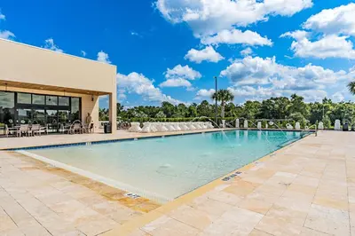 a large swimming pool in front of a building at Magic Villa - 4 En-Suite & BBQ Grill in Orlando