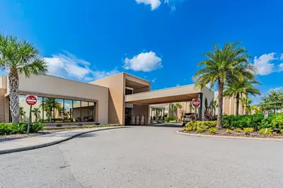 a building with palm trees in front of a street at Magic Villa - 4 En-Suite & BBQ Grill in Orlando