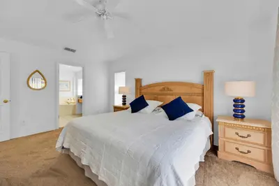 a bedroom with a large bed with blue pillows at Spacious Emerald Home with Pool Lanai Near Disney in Kissimmee