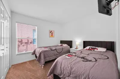 a bedroom with two beds and a window at Spacious Emerald Home with Pool Lanai Near Disney in Kissimmee