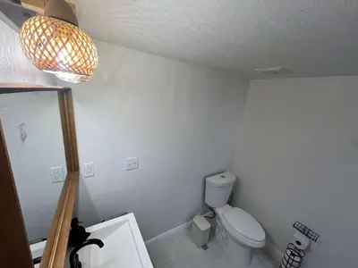 a bathroom with a toilet and a chandelier at Cozy Ground Floor Studio Near Disney in Kissimmee