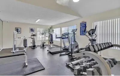 a gym with several treadmills and cardio machines at Cozy Ground Floor Studio Near Disney in Kissimmee