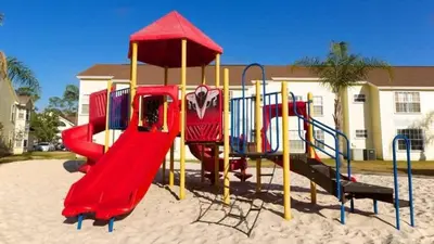 a playground in the sand in front of a house at Cozy Ground Floor Studio Near Disney in Kissimmee