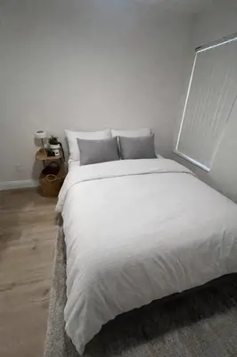 a bedroom with a large white bed with a window at Cozy Ground Floor Studio Near Disney in Kissimmee