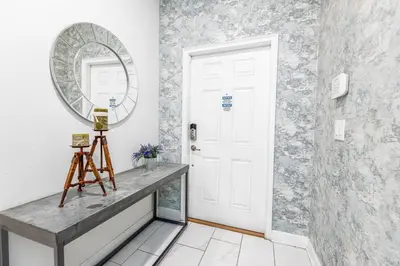 a hallway with a mirror and a table at 4BR Townhome w Pool in Storey Lake - Near Disney in Kissimmee