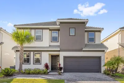 a house with a palm tree in front of it at Upstay Spacious Villa w Pool, Hot Tub & Game Room in Kissimmee
