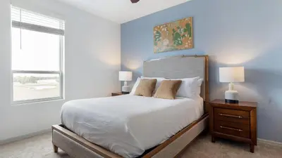 a bedroom with a white bed with two lamps and a window at Landing Stunning 1BD Gym Clubhouse in Orlando