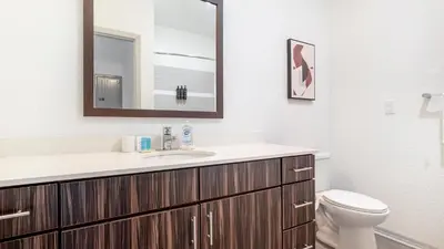 a bathroom with a sink and a toilet and a mirror at Landing Stunning 1BD Gym Clubhouse in Orlando