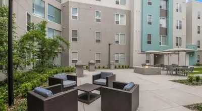 a patio with chairs and tables in front of a building at Landing Stunning 1BD Gym Clubhouse in Orlando