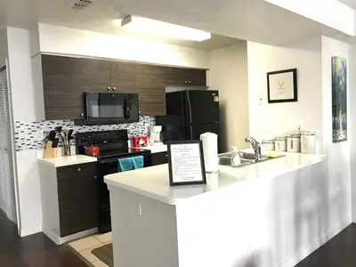 a kitchen with a counter top and a kitchen with a sink at 10min to Disney parks new condo free wifi & pool in Kissimmee