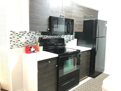a kitchen with a black stove and a microwave at 10min to Disney parks new condo free wifi & pool in Kissimmee