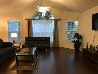 a living room with a couch and a table at 10min to Disney parks new condo free wifi & pool in Kissimmee