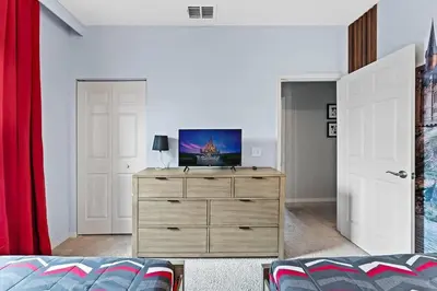 a bedroom with a dresser with a television on it at Townhome 4Q Temático — 15min da Disney in Kissimmee