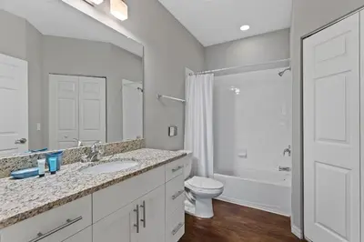 a bathroom with a sink and a toilet and a mirror at Townhome 4Q Temático — 15min da Disney in Kissimmee