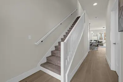 a staircase in a home with white walls and wood floors at Luxury 4 Bedroom Family Getaway w Private Pool in Orlando