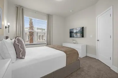 a white bedroom with a large bed and a window at Luxury 4 Bedroom Family Getaway w Private Pool in Orlando