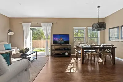 a living room with a dining table and a television at Townhome 4Q no West Lucaya — 15min Disney in Kissimmee