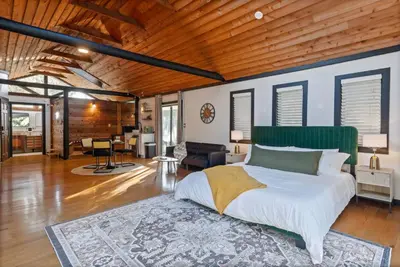 a bedroom with a large bed and a living room at Romantic Getaway Cabin with Jacuzzi in Kissimmee