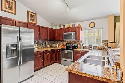 a kitchen with wooden cabinets and stainless steel appliances at The Art House Home for 8 in Orlando