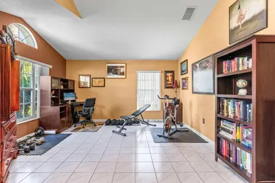 a home gym with a desk and chairs in a room at The Art House Home for 8 in Orlando