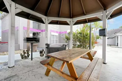 a picnic table in a pavilion with a fireplace at Mickey Family Condo - 4 Miles to Disney in Orlando