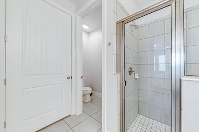 a white bathroom with a shower and a toilet at ECR7609 - 6B Enchanted Vacation Home @Encore in Orlando