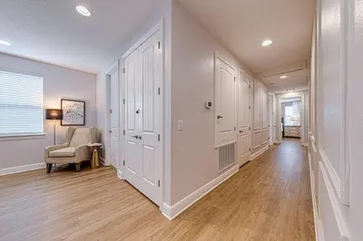 a hallway with white walls and a room with a chair at ECR7609 - 6B Enchanted Vacation Home @Encore in Orlando